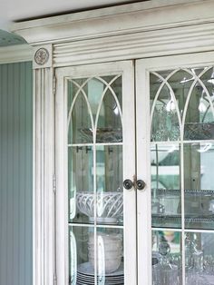 an old china cabinet with glass doors and plates