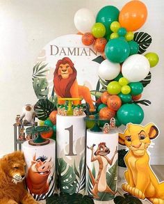 a lion themed birthday party with balloons and jungle animals on the table next to it