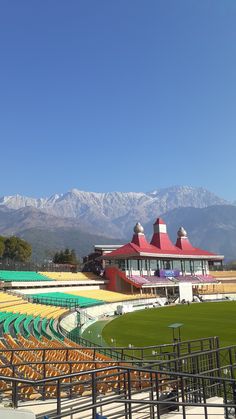 an empty stadium with mountains in the background