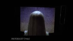 the back of a woman's head is shown in front of a television screen