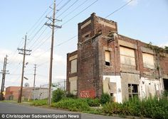 an old brick building with graffiti on it's side and power lines in the background