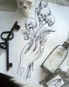 a skull and some flowers on a sheet of paper next to an antique pocket watch