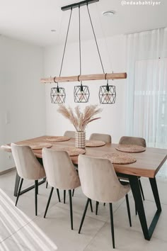 a dining room table and chairs in front of a window