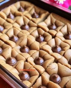 a pan filled with cookies and chocolates on top of a wooden table