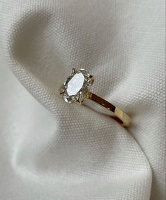 a diamond ring sitting on top of a white cloth