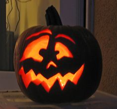 a carved pumpkin sitting on top of a window sill