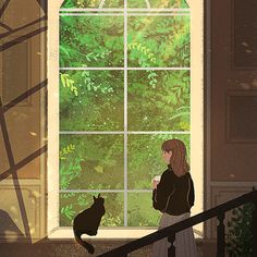 a woman standing in front of a window next to a cat