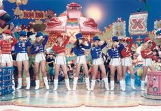 a group of people standing on top of a stage in front of a circus tent