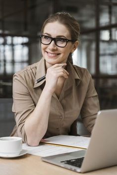 a woman sitting at a table in front of a laptop computer