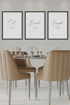 a dining room table with two chairs and three framed pictures on the wall above it