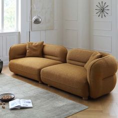 a brown couch sitting on top of a wooden floor