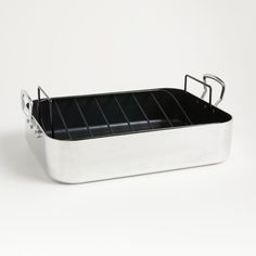 a white and black roasting pan with handles on a white background, it is empty