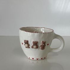 a coffee cup with three bears on it sitting on a white counter top next to a wall