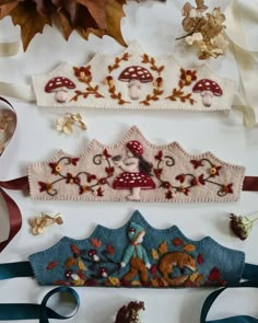 three pieces of embroidered fabric on top of each other with ribbons and bows around them