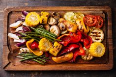 a wooden cutting board topped with assorted veggies