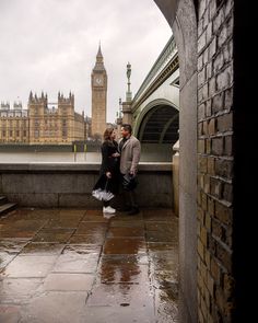 a man and woman standing next to each other in front of the big ben clock tower