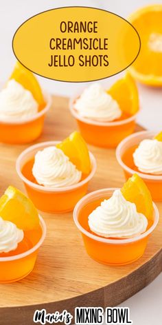 orange creamsice jello shots are arranged on a wooden platter with a speech bubble above them