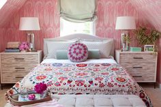 a bedroom decorated in pink and white with flowers on the bed