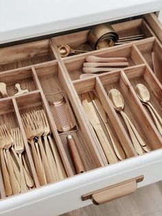 an open drawer filled with wooden utensils and spoons