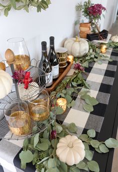 a table topped with wine glasses and plates filled with food on top of a checkered table cloth