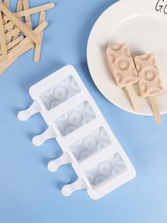 popsicle molds on a plate next to a white plate