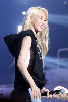 a woman with long blonde hair standing on stage