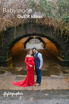 an engaged couple standing in front of a tunnel