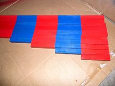 red, white and blue popsicle sticks sitting on top of a cardboard box next to each other