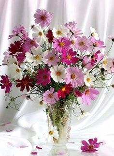 a vase filled with pink and white flowers on top of a table next to the words happy cumalar