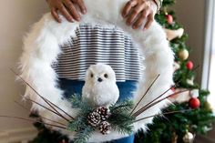 a person holding a wreath with an owl on it