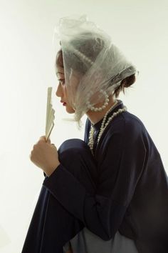 a woman with a veil on her head holding a pair of scissors