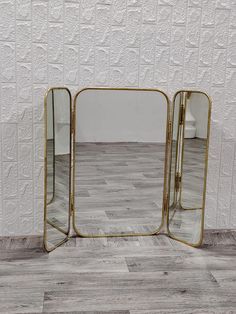 three mirrors sitting on top of a wooden floor