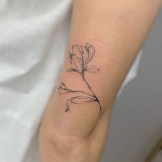 a small flower tattoo on the arm