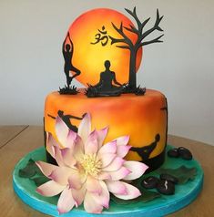 there is a cake that looks like it has yoga figures on it and flowers in the foreground