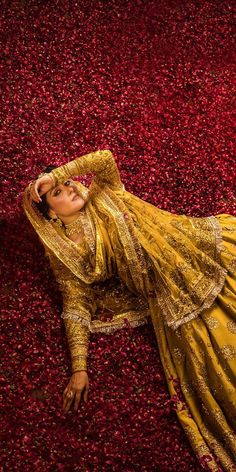 a woman is laying on the ground in a yellow dress with gold sequins