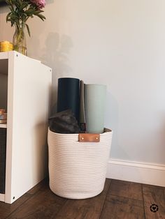 a basket that has some items in it next to a vase with flowers on top