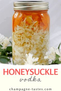 a jar filled with shredded white flowers and the words honeysuckle vodka on top