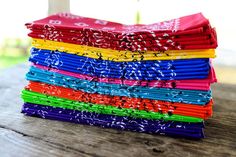 a stack of colorful cloths sitting on top of a wooden table