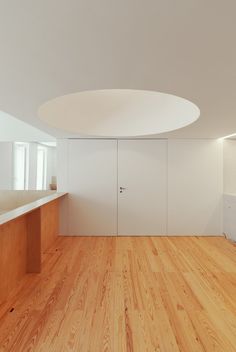 an empty room with wooden floors and white walls, is pictured in this image from the inside