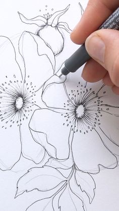 a person is drawing flowers with a marker