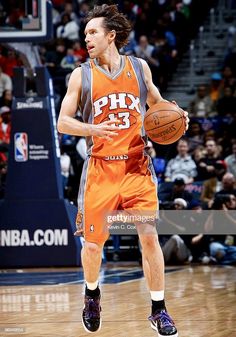 a basketball player dribbling the ball in front of an audience at a game