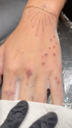 a woman's hand with stars on it and an object next to her arm