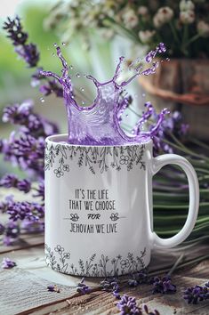 a white coffee mug with purple water splashing out of it and the words, it's the life that we choose sevoah we live