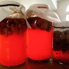 three jars filled with liquid sitting on top of a table