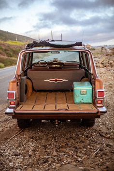 the back end of an old car with luggage in it