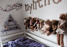 there are many stuffed animals hanging on the wall in this child's bed room