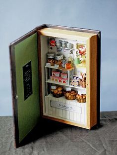 an open refrigerator with food in it sitting on top of a table next to a wall