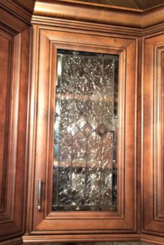 a kitchen cabinet door with glass inserts on the front and side panels that have been stained brown