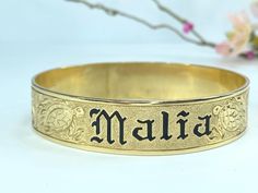 Add a special touch to your Hawaiian jewelry collection with this 14K gold bracelet. This beautiful bracelet features black enamel custom name lettering, making it a truly unique piece. With a width of 15.2mm, this bracelet fit 8.0" wrist, weight 45.3 gram.  Today, Hawaiian heirloom jewelry is hand crafted, as it has always been. Although Hawaiian bracelets are the most traditional style of heirloom jewelry, more variations have surfaced over the years. Because of its timeless beauty, all the magic, tradition and pride of the Hawaiian culture becomes yours when you wear our cherished collectibles. It is why the people of Hawaii say, "To own a piece of Hawaiian jewelry is to own a piece of Hawaii."  Retail $5,595 Name Lettering, Hawaiian Heirloom Jewelry, Hawaiian Bracelets, Sabyasachi Jewellery, Heirloom Jewelry, Hawaiian Jewelry, Hawaiian Culture, Heirlooms Jewelry, Bracelet Black