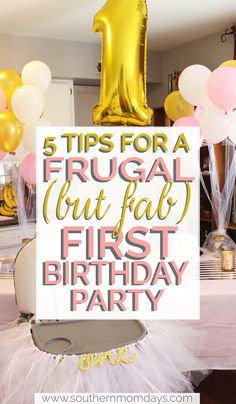 a first birthday party with gold balloons and white table cloths, pink tutu skirt